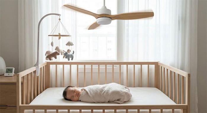 Em bé sơ sinh đang ngủ ngon giấc, an toàn dưới làn gió tự nhiên êm ái của quạt trần động cơ DC