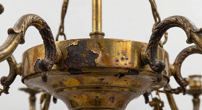 Cận cảnh khung kim loại của đèn chùm bị oxy hóa, gỉ sét và ố vàng