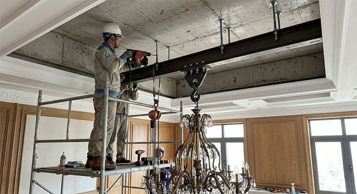 Kỹ sư thực hiện kỹ thuật khoan cấy ty ren gia cố trần chịu lực cho đèn chùm nặng