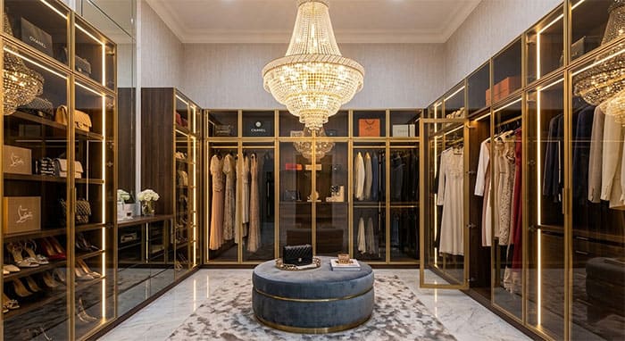 Phòng thay đồ Walk-in Closet xa hoa với hệ tủ kính và đèn thả pha lê trung tâm