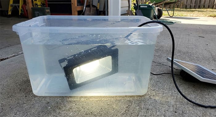 Thử nghiệm ngâm đèn pha năng lượng mặt trời đang sáng vào trong bể nước