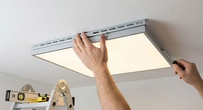 Tận dụng rãnh trượt trên giá đỡ để căn chỉnh lại mép đèn cho song song với tường trước khi siết ốc